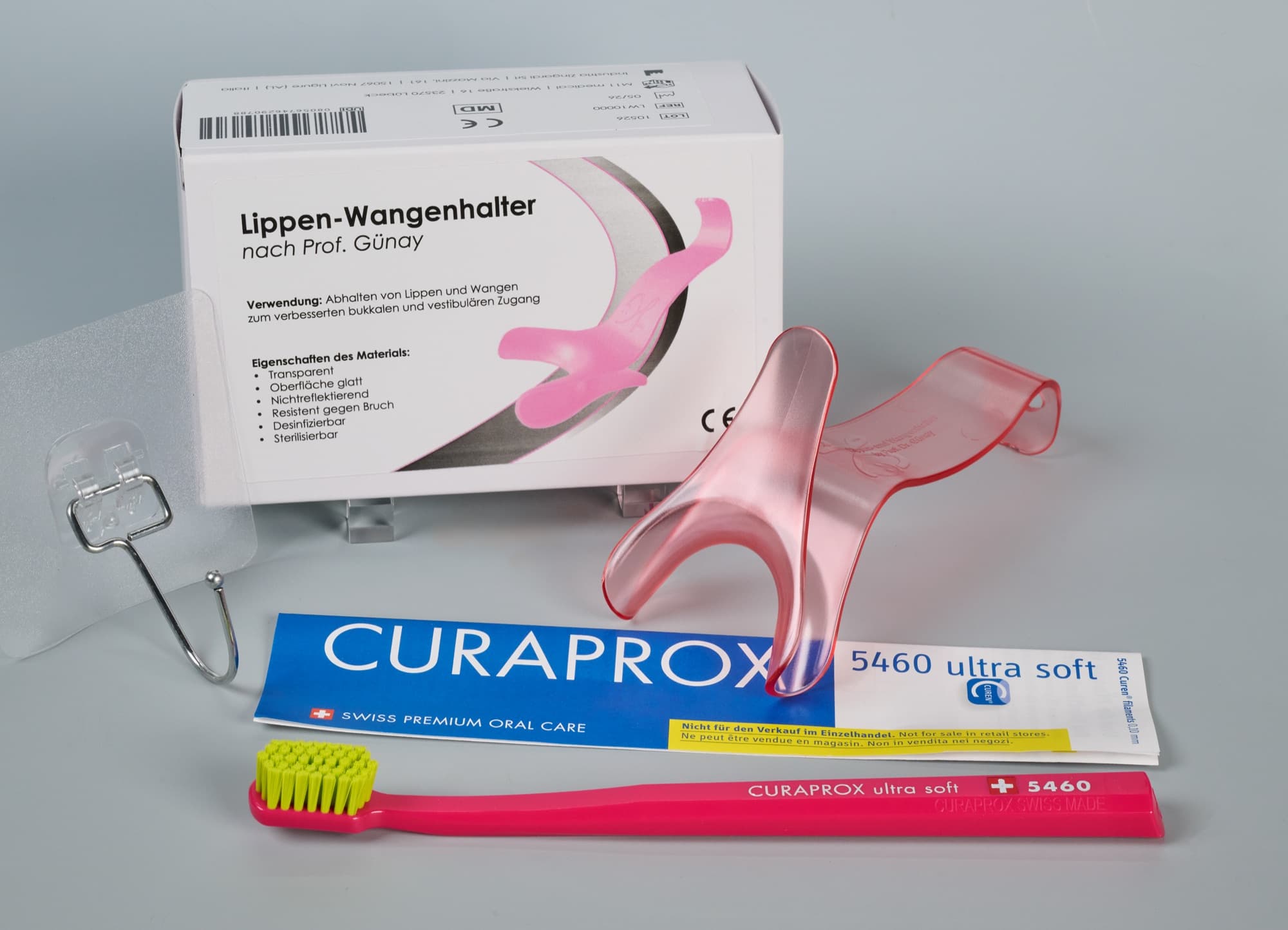 Lieferumfang der Einführungspackung: Umkarton, Lippen- und Wangenhalter, Klebehaken und eine Curaprox CS 5460 ultra soft Zahnbürste